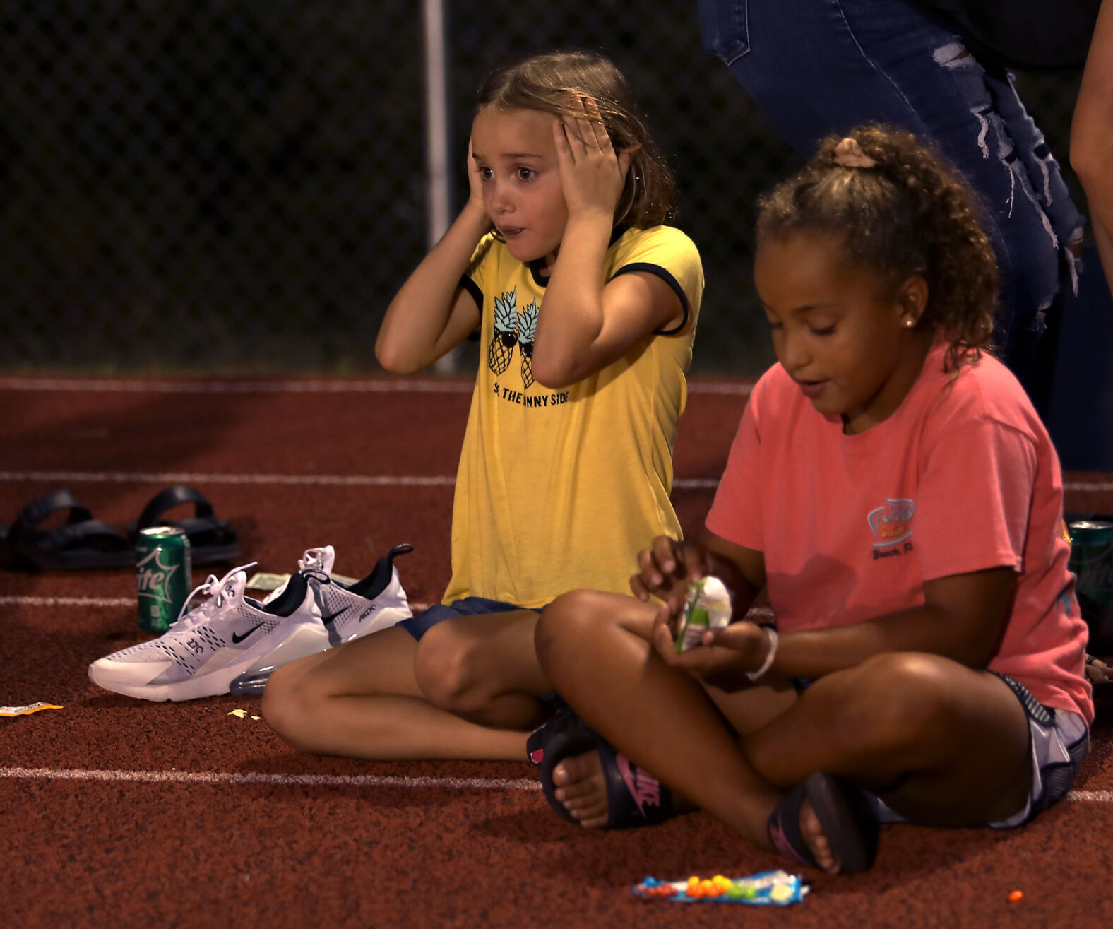 Avery Isgrig, 7, left, puckers her face